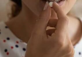 Taking meds. Close up cropped shot of young lady hold glass of water prepare to swallow pill. Sick woman drink painkiller antidepressant fat burner supplement antibiotics use emergency contraception